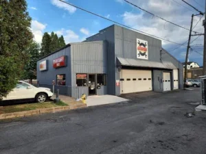 Gray commercial building with large garage doors and signage.